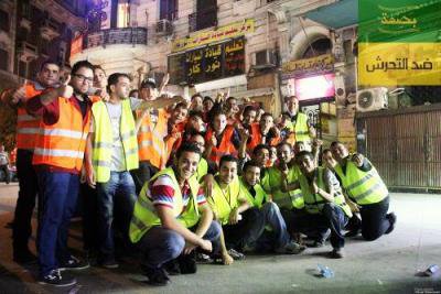 Posed group photo of about twenty young men in high-visibility jackets.