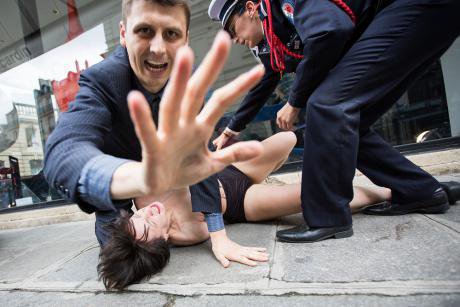 FEMEN activist is tackled to the ground.