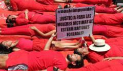 Women dressed in red lying down in a protest stunt