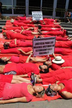Women dressed in red lying down in a protest stunt