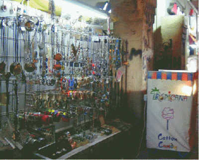 Street stall with jewelry on display and a 'Tropicana' sign