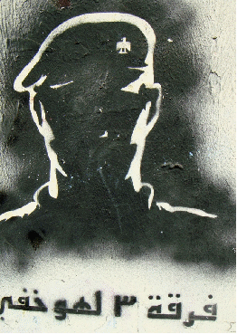 Grafitti stencil of a sinister face with Arabic script below