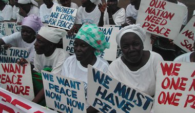 Liberian Women, all dressed in white, protesting with signs 