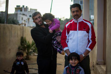 Naji Al Roahma with his two children and Syrian neighbors