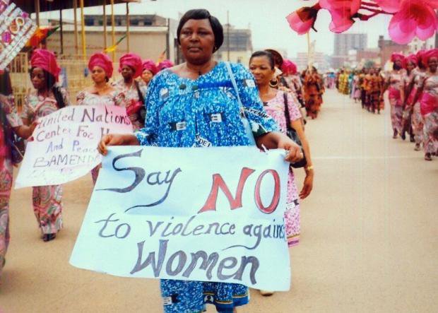 Women on a protest in Cameroon holding banners saying &#39;Say no to violence against women&#39;