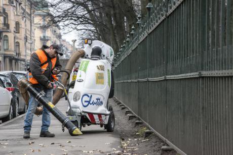 Migrant worker cleaning the Tavricheskaya st., from the leaves, by big vacuum cleaner. Russia, Saint-Petersburg, Tavricheskay st. - Kalabi Yau - Shutterstock.jpg
