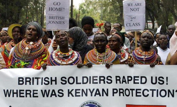 A line of Kenyan women hold up a banner reading 