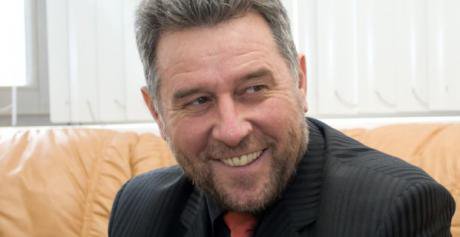 Kutayev smiling on a couch.