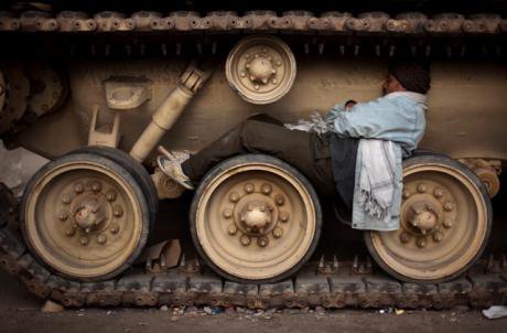 An Egyptian anti-Mubarak protesters sleeps on the wheels of a tank in Tahrir square, Cairo. (AP Photo/Emilio Morenatti)