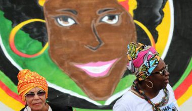 Duas mulheres juntam-se a milhares de mulheres negras de todo o Brasil num protesto contra a violência e a discriminação em Bras