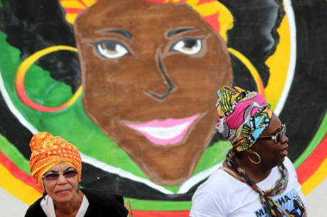 Duas mulheres juntam-se a milhares de mulheres negras de todo o Brasil num protesto contra a violência e a discriminação em Bras