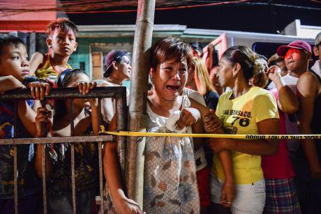 A woman cries near the body of a suspected drug user, shot dead north of Manila. 