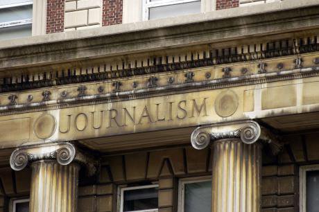 Pediment of neoclassical building with 'Journalism' carved into it.