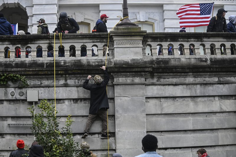 A Donald Trump supporter climbs the walls of the United States Capitol during the Trump inspired insurgency.