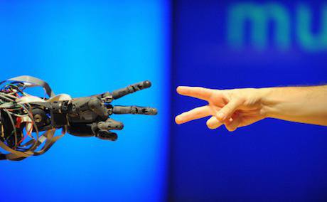 A robot faces off against a human in a game of &#39;rock paper scissors&#39; at the Science Museum, London.