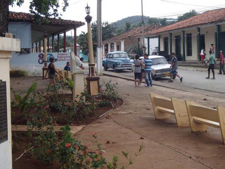 La Palma Park in Cuba with benches and passers by in sight