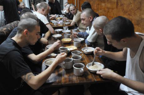 Shaven patients at City Without Drugs eat breakfast together.