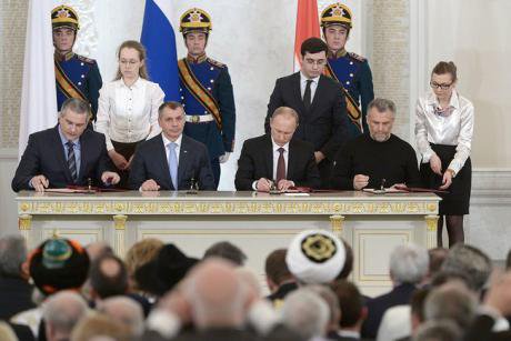 Vladimir Putin formally integrates Crimea into the Russia, flanked by Sergei Aksyonov and Aleksei Chaly. 