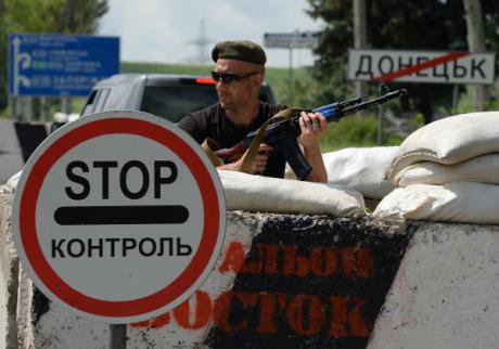 А member of the Vostok Battalion guards a roadblock at the entrance to Donetsk