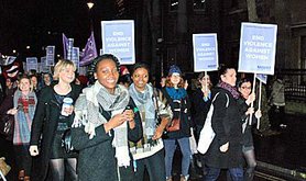 Women marching with placards in the dark