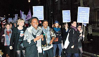 Women marching with placards in the dark