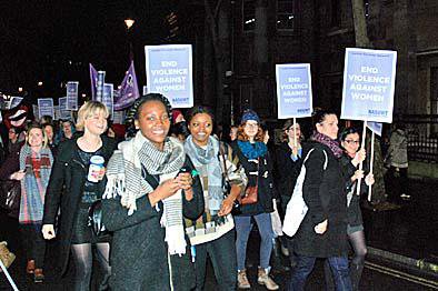 Women marching with placards in the dark