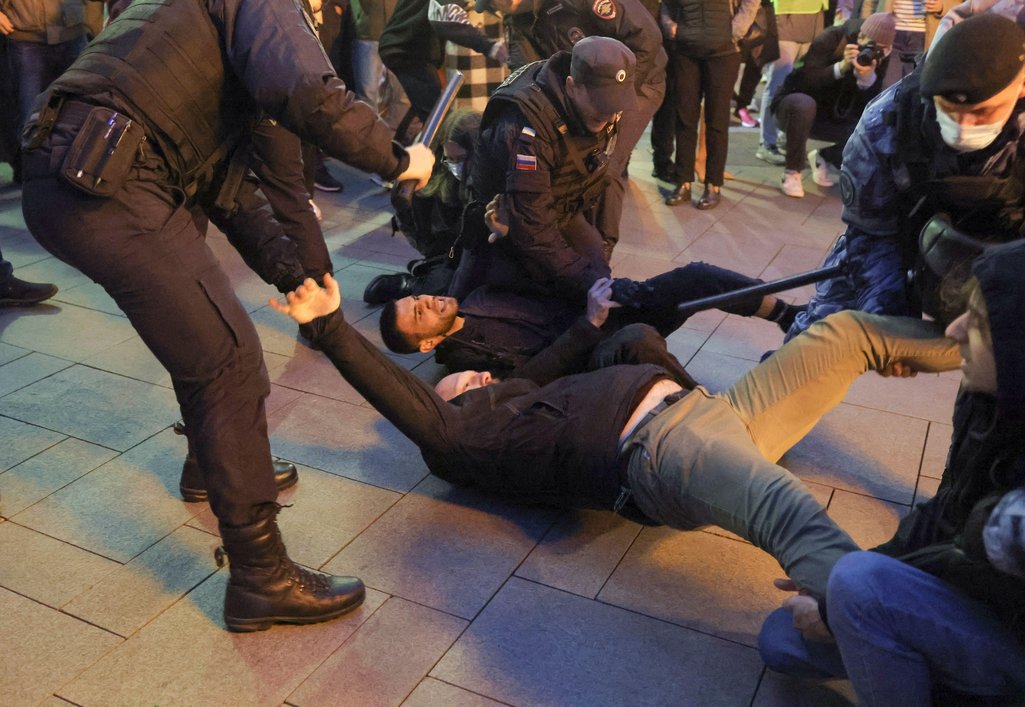 Russian police officers detain men at rally