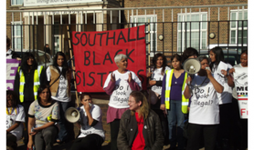 Women demonstrating with a Southall Black Sisters banner and megaphone