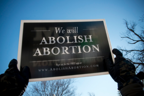 A protester holds an abolish abortion sign at a rally attended by young people in Washington DC, 22 January 2014.