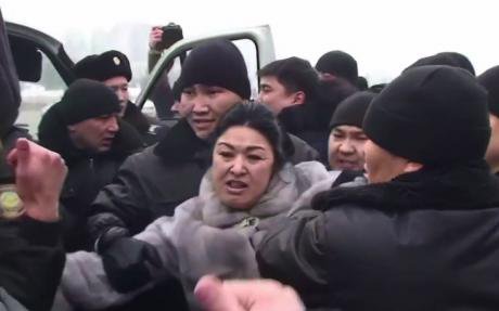 Police arrest a woman at an unsanctioned protest of Kazakhstan's currency devaluation. 15