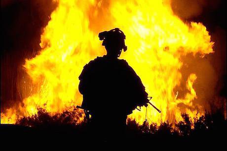 Soldier watches a blaze in Iraq, 2008. David Marshall. The US Army/Flickr. Some rights reserved.