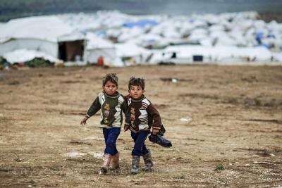 Syrian boys, whose family fled their home in Idlib, walk to their tent, at a camp for displaced Syrians, in the village of Atmeh, Syria, Monday, Dec. 10, 2012_0_0.jpg