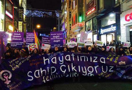 Women march at night with a banner