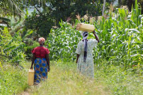 Women have to walk for miles to collect water after being displaced from their land in Uganda.