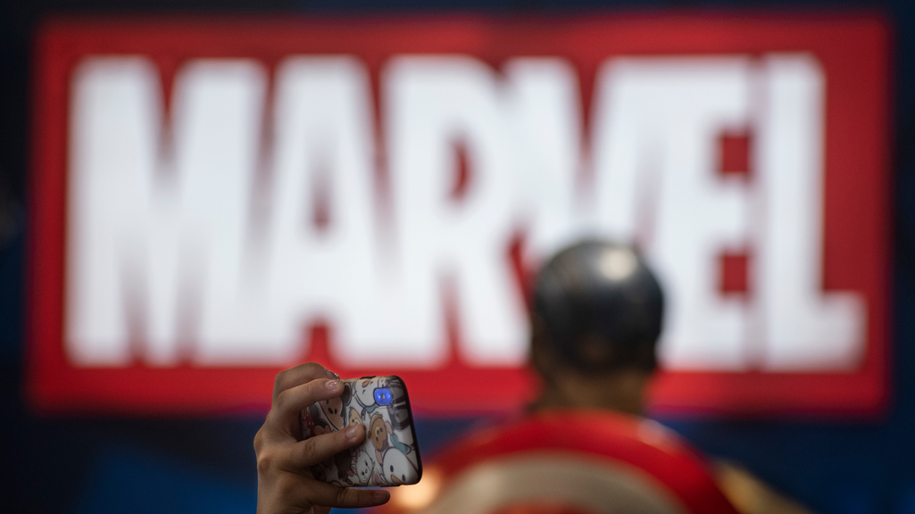 A visitor takes photos at Marvel Avengers movie character figures at Disney's Marvel Studio booth during the Ani-Com & Games event in Hong Kong.