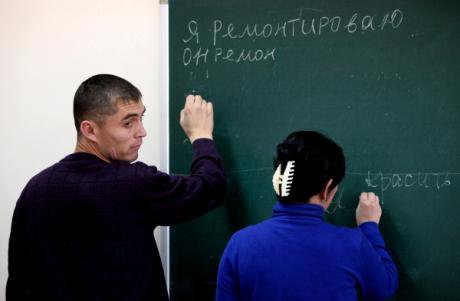 A Russian lesson in Vladivostok. Students attempt to conjugate the verbs 'to repair' and 'to paint'.