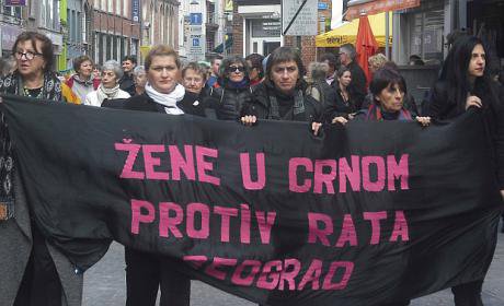 Women march holding a banner