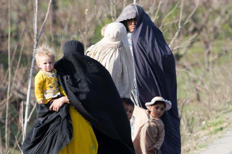 Heavily veiled women walk with their children in Swat valley, 2013.