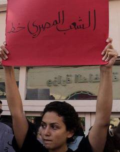 Young woman holding a banner with Arabic text on it