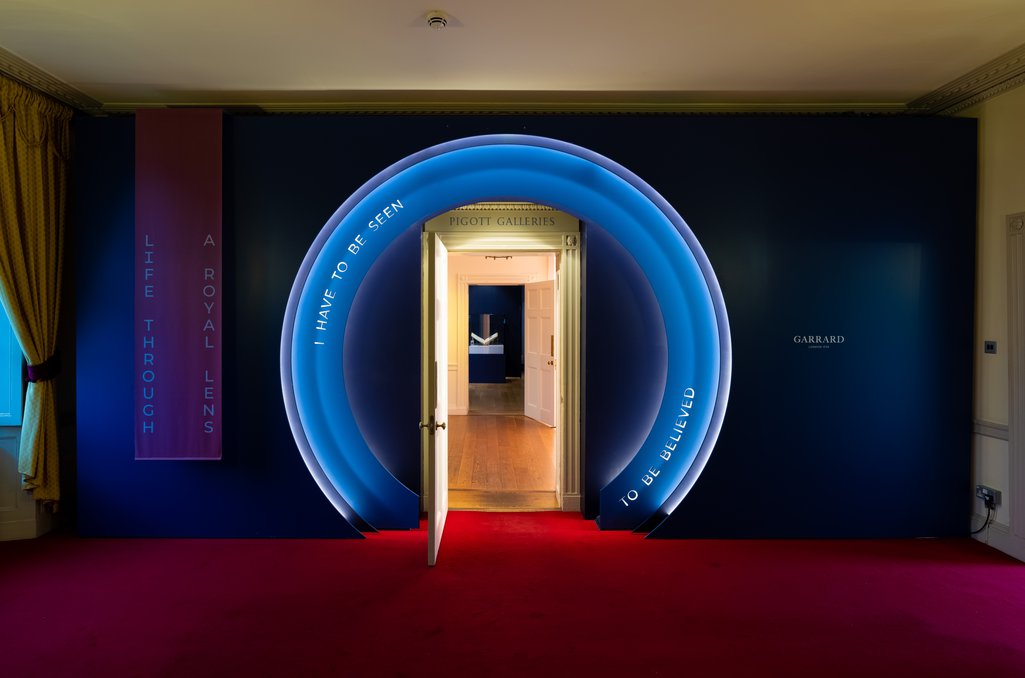 Entrance to 'Life Through a Royal Lens' exhibition: a doorway surrounded by a frame resembling a camera lens mounting