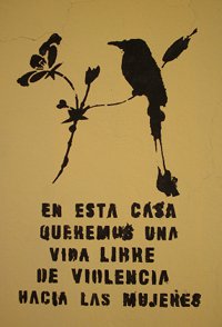 Image and words stencilled on external wall "En esta casa queremos una vida libre de violencia hacia las mujeres"