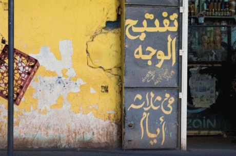 A wall with a painted sign in Arabic
