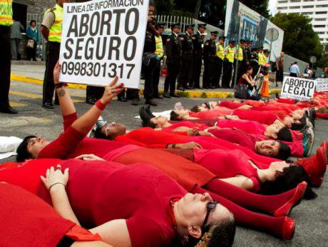 Women dressed in red lying in the street