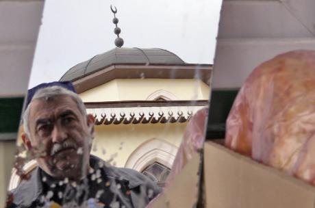 An older Tatar man in front of a mosque.