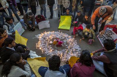 Mixed group of people seated in a circle around messages and candles.