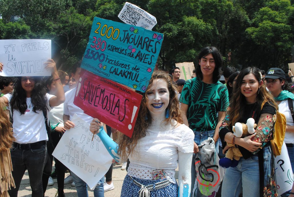 A young climate protester holds up a placard demanding action to save endangered species at a rally in Mexico City.