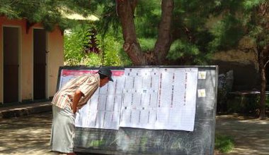 An Indonesian citizen reviews a list of parliamentary candidates
