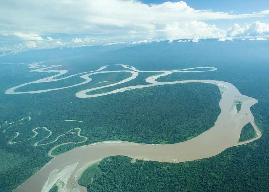 A birds-eye view shot shows the river snaking through the rainforest