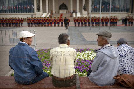Men watch a parade by the Mongolian National Guard. Photo: Mark Schiefelbein/ AP/Press Association Images. All Rights Reserved