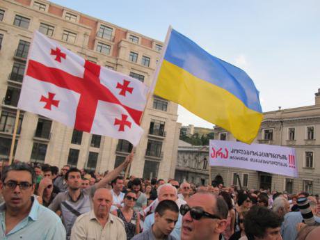 Georgian & Ukrainian flags fly alongside a banner opposing any compromise with 'collaborators'